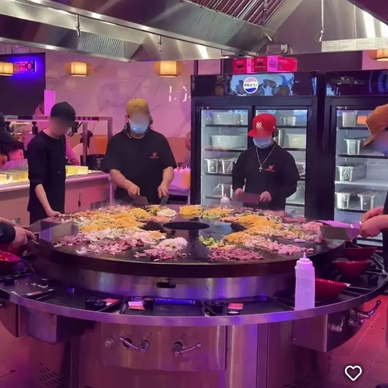 Cooking various ingredients on a large hot plate at Hungry Bowl, a Buffet Restaurant in Bowie